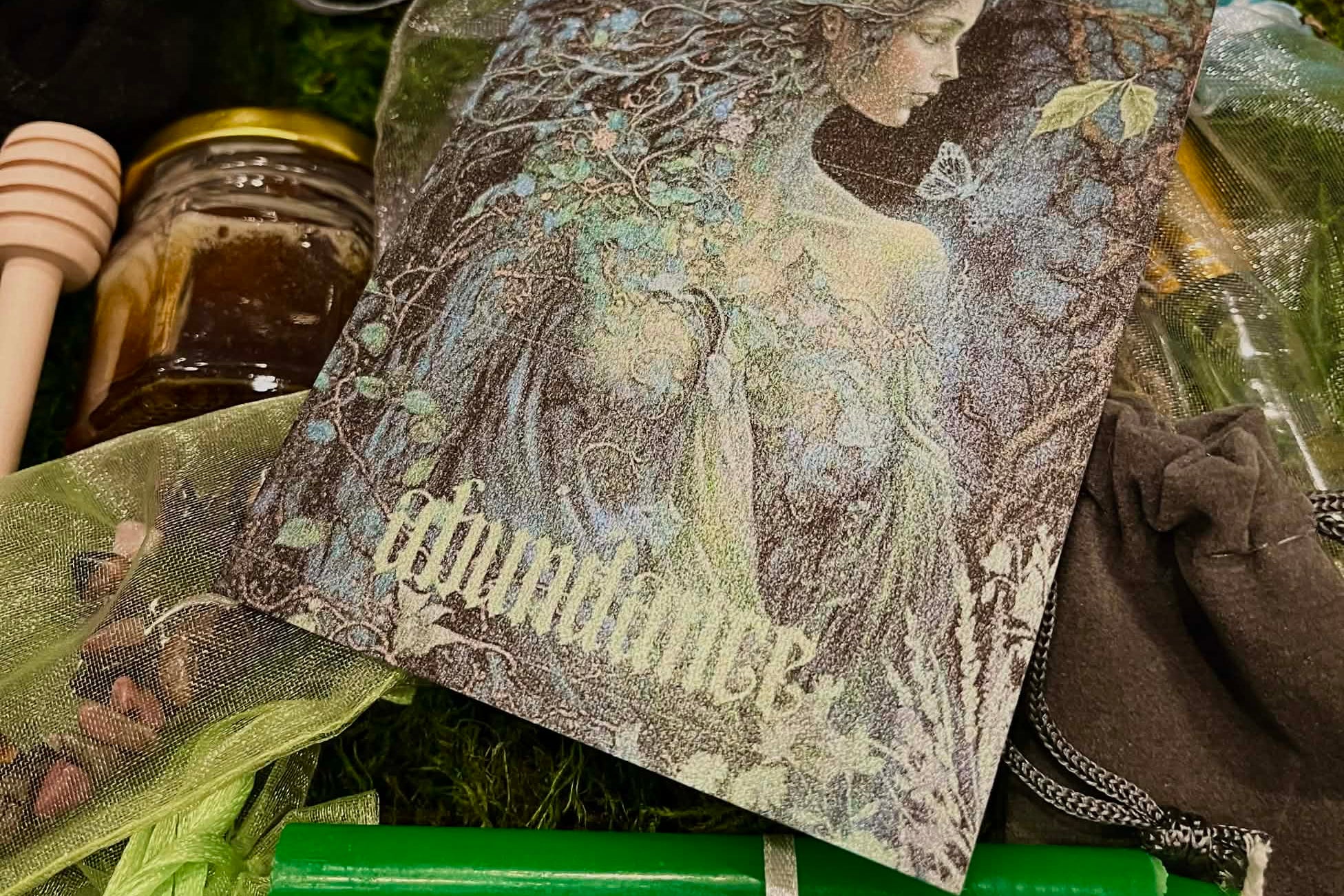 Beltane Sabbat Box xperience with organic honeycomb, anointing oil, incense, green candle, white candle w/greenman charm. Abundance altar card.